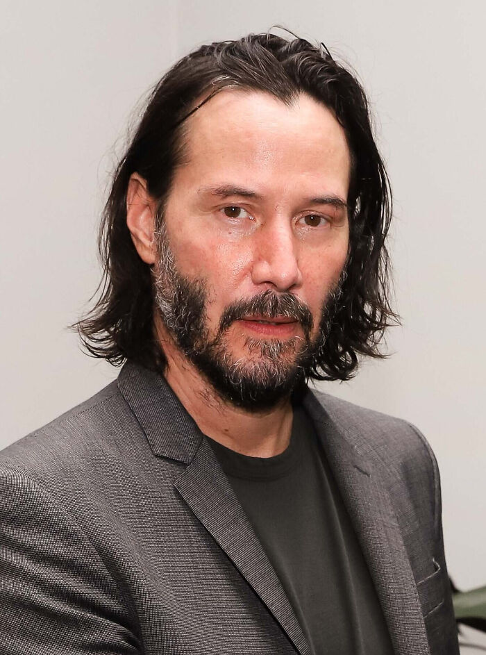 Man with medium-length dark hair and beard, wearing a gray blazer and black shirt, related to celebrity gossip discussions.