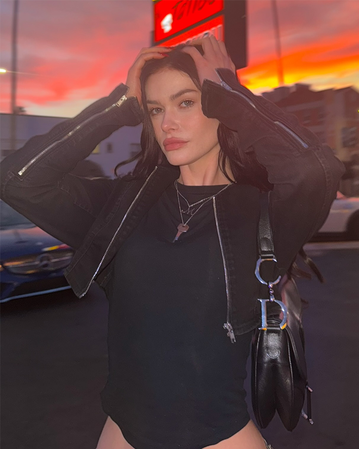 Young woman posing outdoors at sunset, wearing a black jacket and necklace, capturing massive praise in a viral clip. Young woman posing outdoors at sunset, wearing a black jacket and necklace, capturing massive praise in a viral clip.