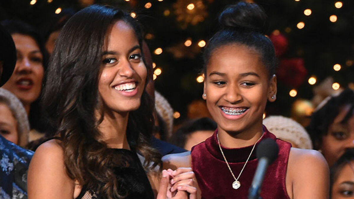 Sasha Obama and Malia smiling together at a festive party, showcasing Sasha Obamau2019s figure and their close bond.