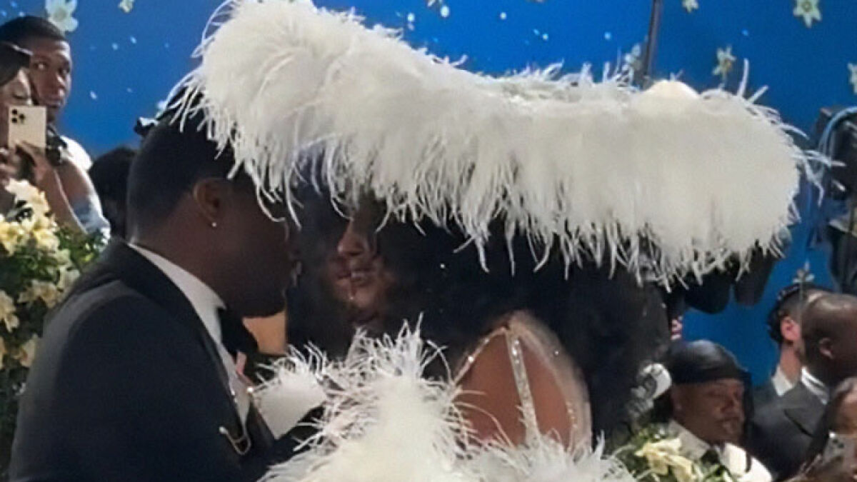 Zendaya reacting with surprise wearing a feathered hat as Diana Ross upstages her at the Met Gala red carpet event.