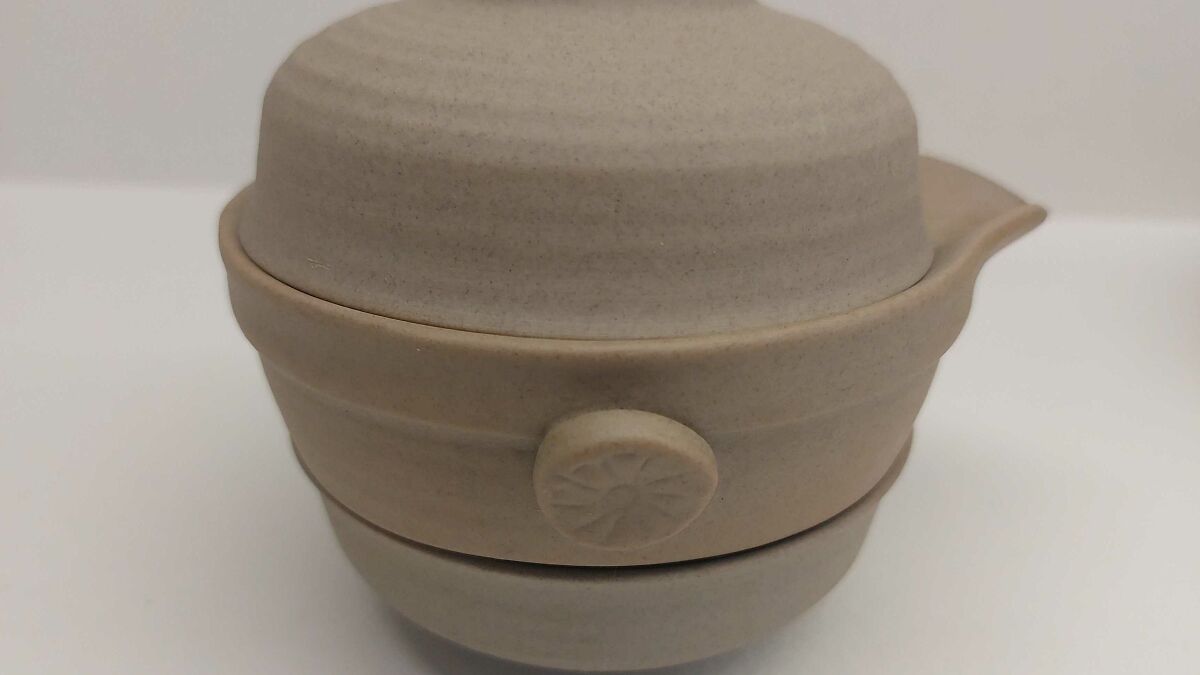 Confusing item made of beige ceramic with three stacked rounded sections and a small spout on the side.