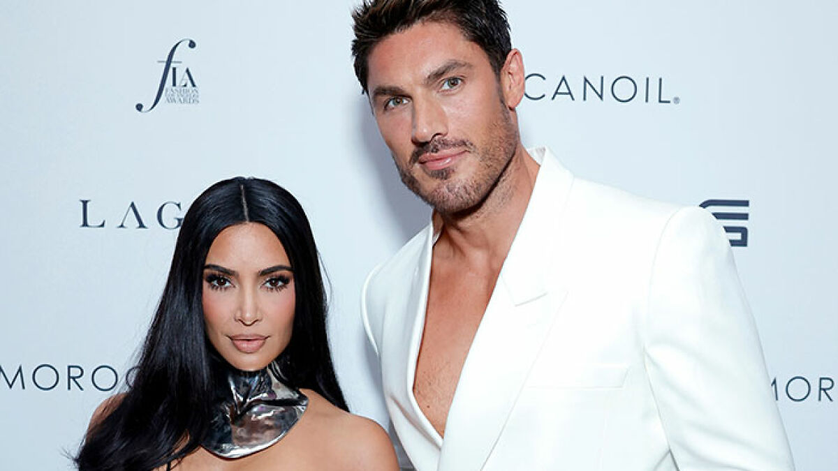 Kim Kardashian's hair stylist posing in a white suit, flaunting his body and bulge at a Cannes event.