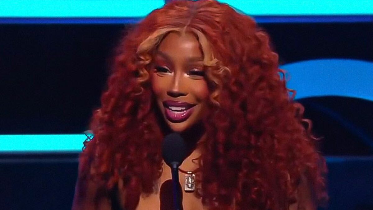 Performer with long curly red hair speaking at microphone during cringeworthy moments at 2025 AMAs award show.