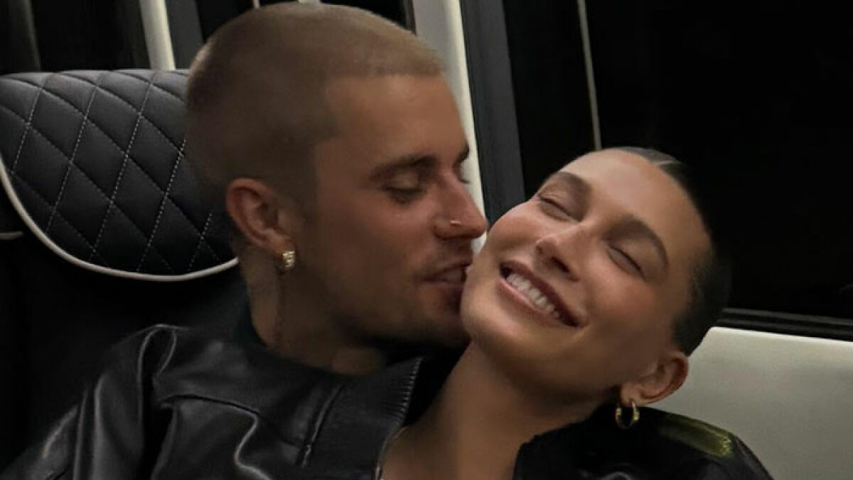 Justin Bieber affectionately close to wife Hailey, smiling and sharing an intimate moment in a cozy setting.