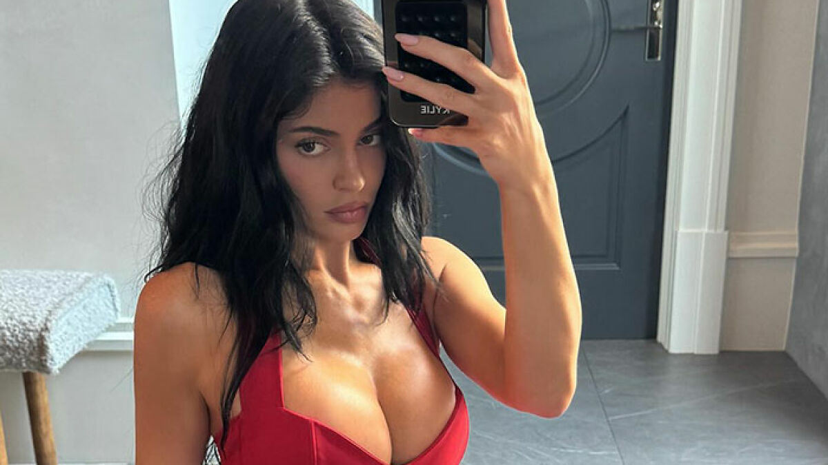 Kylie Jenner taking a selfie in a low-cut red dress, sparking fan concern over her recent photo.