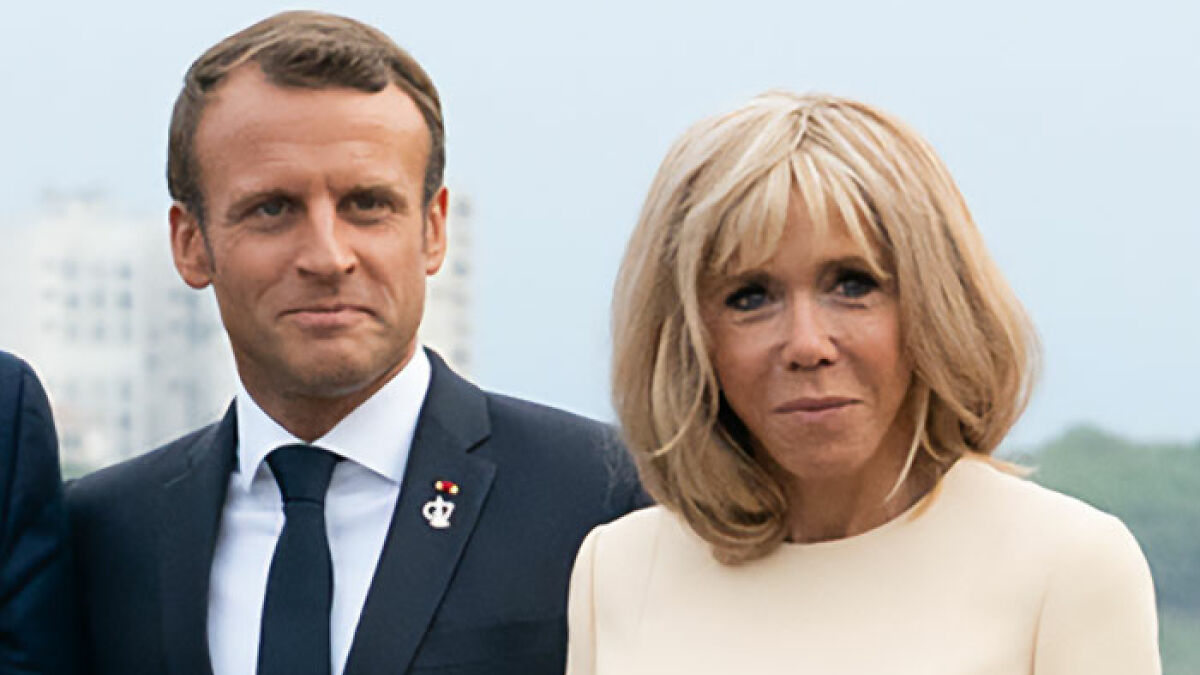 Emmanuel and Brigitte Macron at an event, spotlighting grooming rumors and their teacher-student past.
