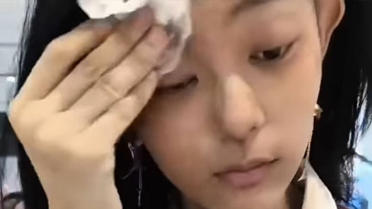 Passenger wiping off makeup at airport after facial recognition failed to identify her causing humiliation.