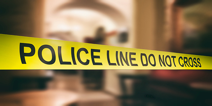 Yellow police line tape blocking access in a blurred indoor crime scene related to fatal beating incident. Yellow police line tape blocking access in a blurred indoor crime scene related to fatal beating incident.