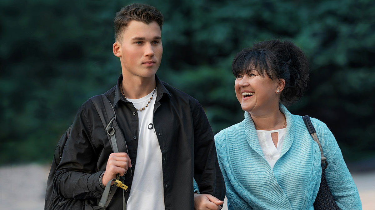 Teenager walking with his mom outdoors, highlighting stepmom tantrum after graduation invitation choice.