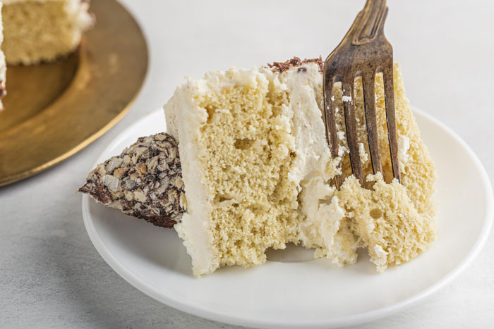 Slice of creamy cake on a white plate with fork, highlighting confusion about eggs being dairy in dairy-free baking. Slice of creamy cake on a white plate with fork, highlighting confusion about eggs being dairy in dairy-free baking.