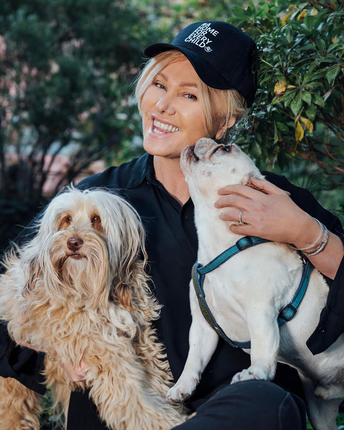 Deborra-Lee Furness smiling outdoors with two dogs, reflecting on her journey of betrayal and divorce filing. Deborra-Lee Furness smiling outdoors with two dogs, reflecting on her journey of betrayal and divorce filing.