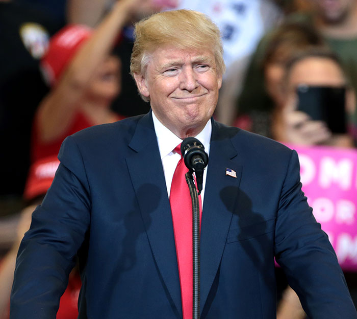 Former President Donald Trump speaking at a rally, in focus amid blurred enthusiastic crowd background. Former President Donald Trump speaking at a rally, in focus amid blurred enthusiastic crowd background.