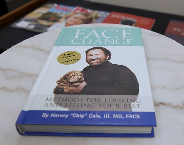 Book titled Face Change by a plastic surgeon displayed on a marble table, highlighting facial enhancement methods. Book titled Face Change by a plastic surgeon displayed on a marble table, highlighting facial enhancement methods.