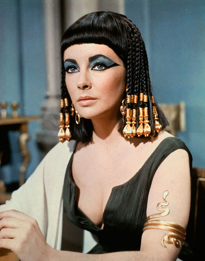 Elizabeth Taylor as Cleopatra with dramatic eye makeup, showcasing the mystery of her iconic eyes in pop culture.