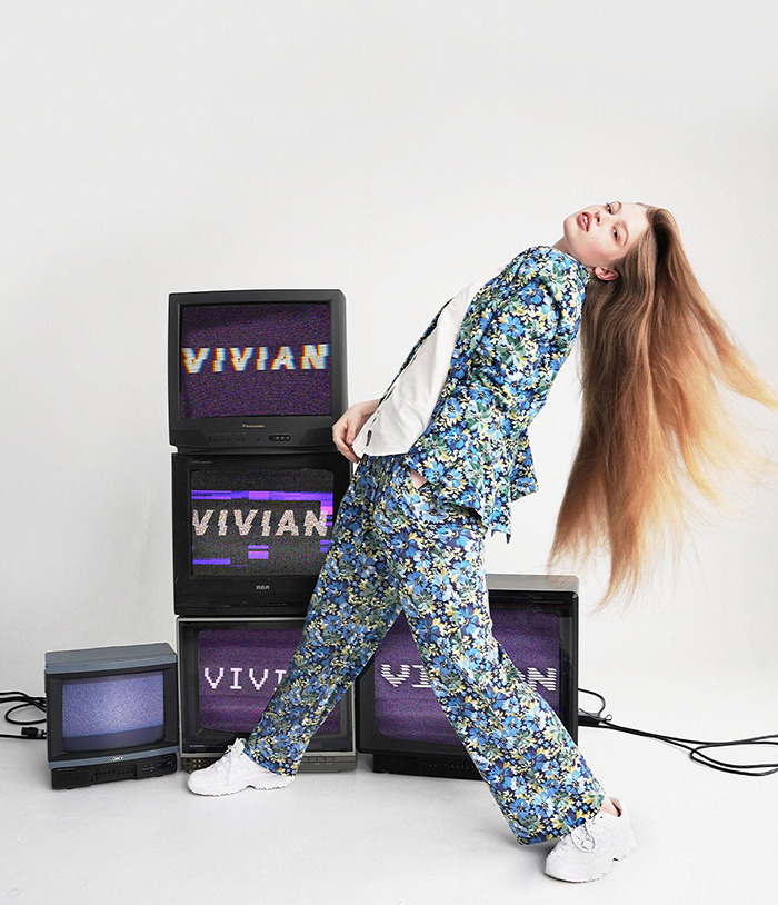 Vivian, Elon Musk's trans daughter, posing in a floral suit surrounded by vintage TVs displaying her name. Vivian, Elon Musk's trans daughter, posing in a floral suit surrounded by vintage TVs displaying her name.