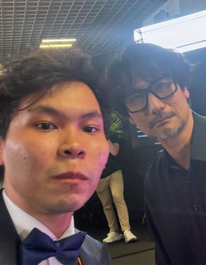 Two men posing for a close-up selfie, with focus on Emma Stone responding to reporter at Cannes event. Two men posing for a close-up selfie, with focus on Emma Stone responding to reporter at Cannes event.