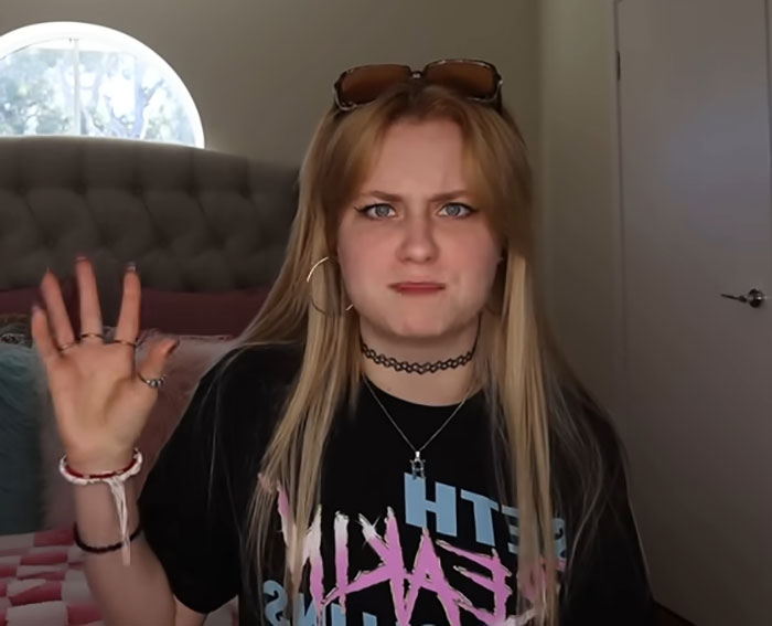 Young woman expressing concern while discussing companies using AI to conduct job interviews in a casual indoor setting. Young woman expressing concern while discussing companies using AI to conduct job interviews in a casual indoor setting.