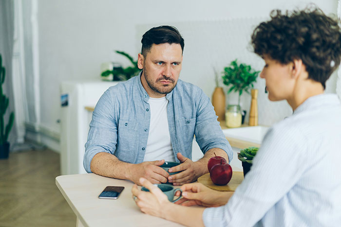 Man and woman having a tense conversation in an apartment on Valentine’s Day after breakup with ex-fiance. Man and woman having a tense conversation in an apartment on Valentine’s Day after breakup with ex-fiance.
