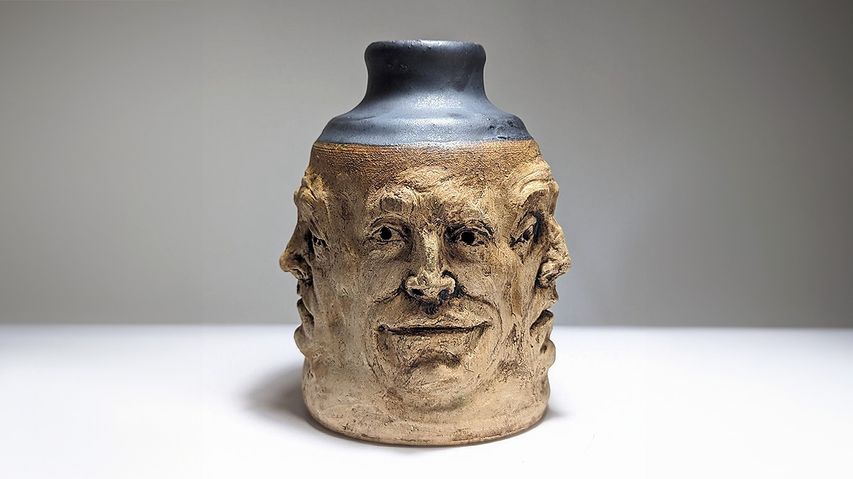 Ceramic art vase with multiple human faces sculpted, showcasing creativity inspired by mental health struggles.