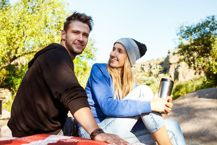 Young man and woman outdoors, smiling and enjoying nature, illustrating lost friendships and ultimatums between friends.