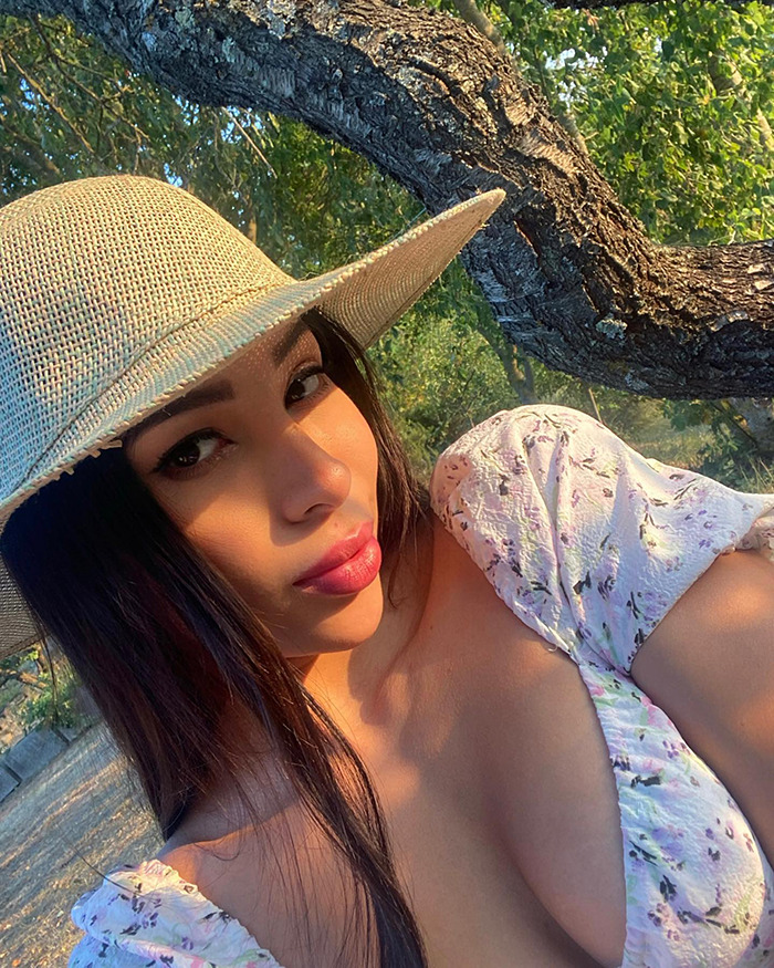 Woman in a sunhat posing outdoors with trees in the background symbolizing tourist abducted and left in coma stories. Woman in a sunhat posing outdoors with trees in the background symbolizing tourist abducted and left in coma stories.