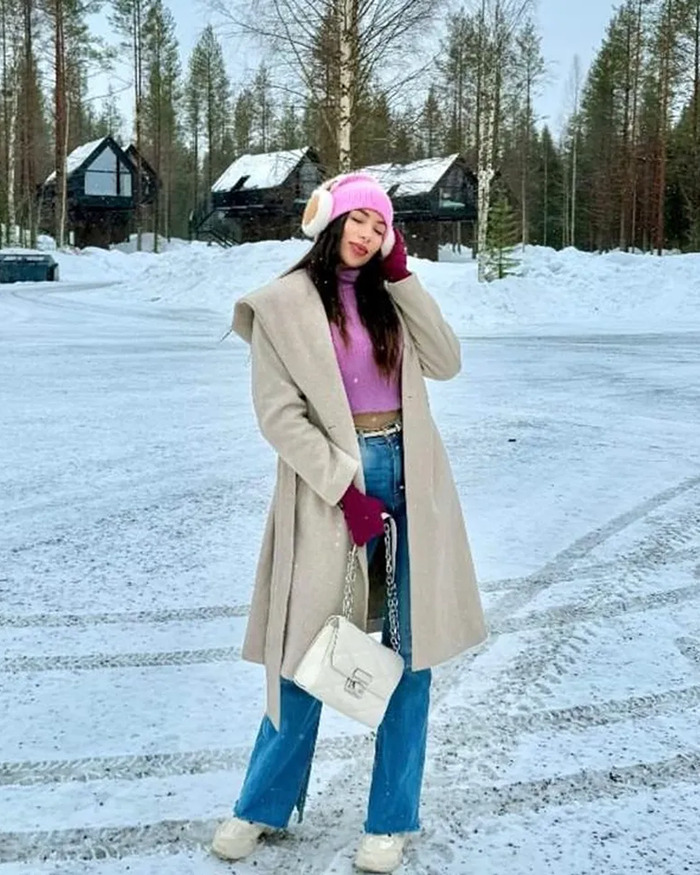 Young tourist in winter coat and pink hat stands in snowy vacation hotspot, related to heartbreaking final texts before coma. Young tourist in winter coat and pink hat stands in snowy vacation hotspot, related to heartbreaking final texts before coma.