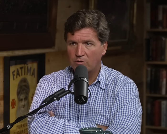 Man in a checkered shirt speaking into a microphone during a discussion about US secret $21 trillion underground city claims. Man in a checkered shirt speaking into a microphone during a discussion about US secret $21 trillion underground city claims.