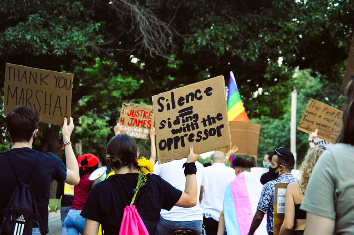 Protesters holding signs advocating against misogyny and gender-based violence in an outdoor demonstration. Protesters holding signs advocating against misogyny and gender-based violence in an outdoor demonstration.