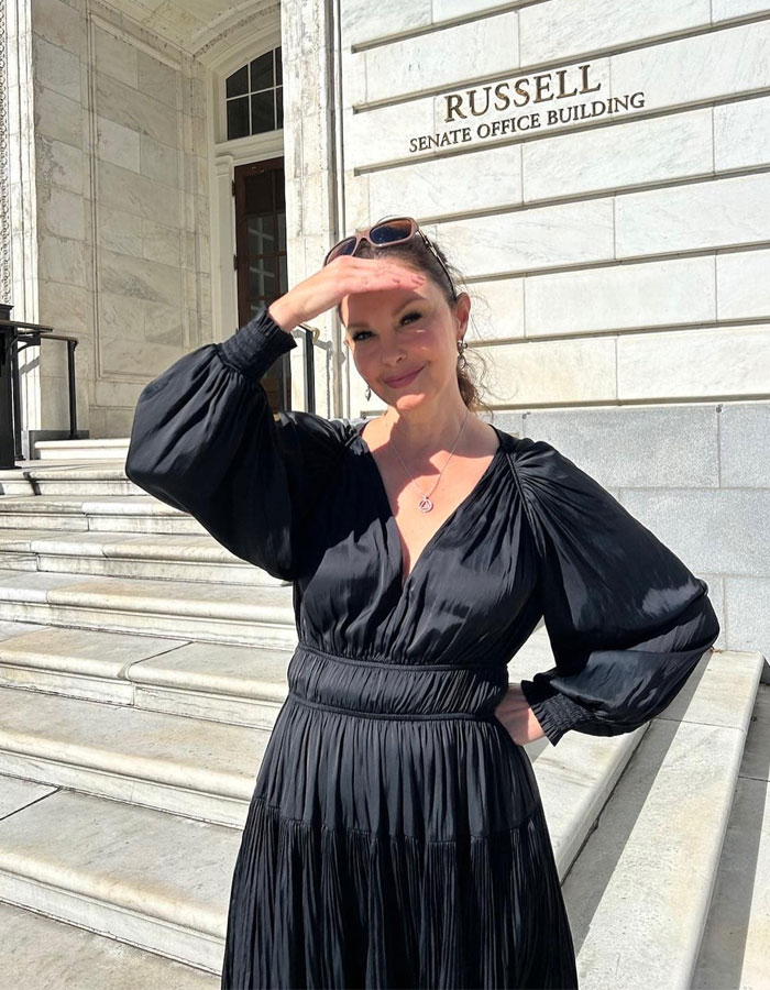 Woman standing outside Russell Senate Office Building, shielding eyes from sun, symbolizing strength against misogyny and gender violence. Woman standing outside Russell Senate Office Building, shielding eyes from sun, symbolizing strength against misogyny and gender violence.