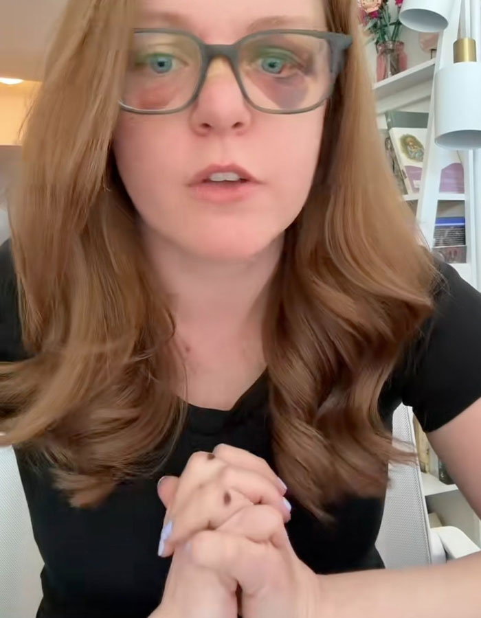 Woman with glasses and long hair speaking about misogyny and gender-based violence in an indoor setting. Woman with glasses and long hair speaking about misogyny and gender-based violence in an indoor setting.