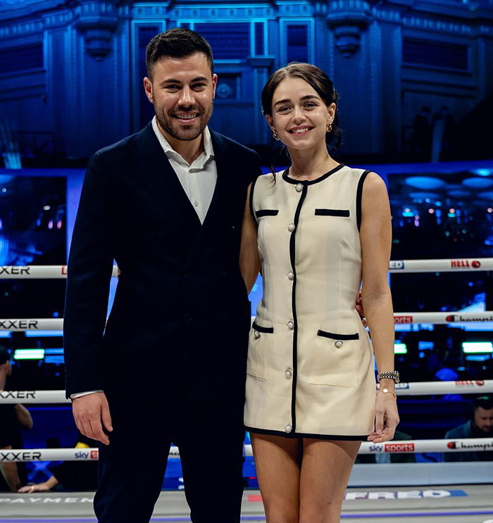 Man and woman standing in a boxing ring, smiling, with focus on pro boxer Georgia O’Connor’s appearance. Man and woman standing in a boxing ring, smiling, with focus on pro boxer Georgia O’Connor’s appearance.