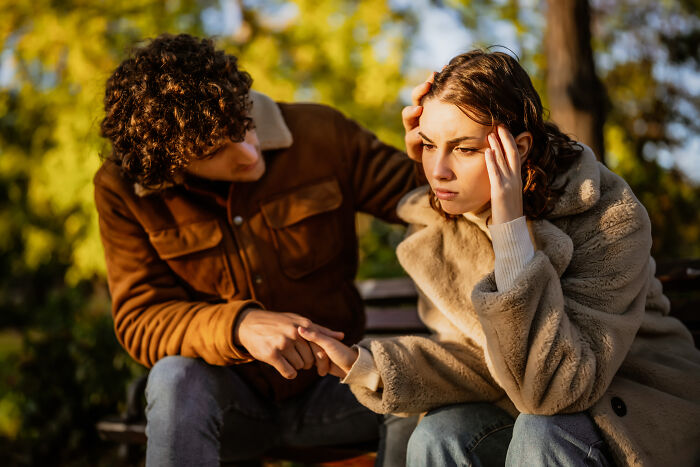 Man comforting distressed woman outdoors, illustrating the emotional impact of losing amazing partners and coping with grief.