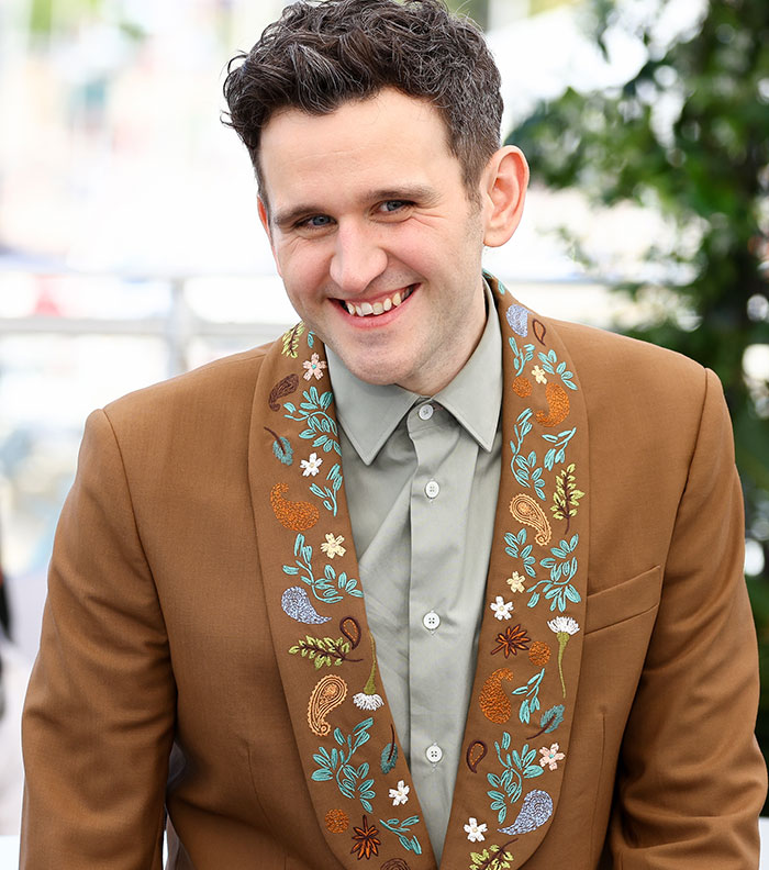 Actor in Harry Potter star in x-rated gay film wearing brown embroidered jacket smiling outdoors Actor in Harry Potter star in x-rated gay film wearing brown embroidered jacket smiling outdoors