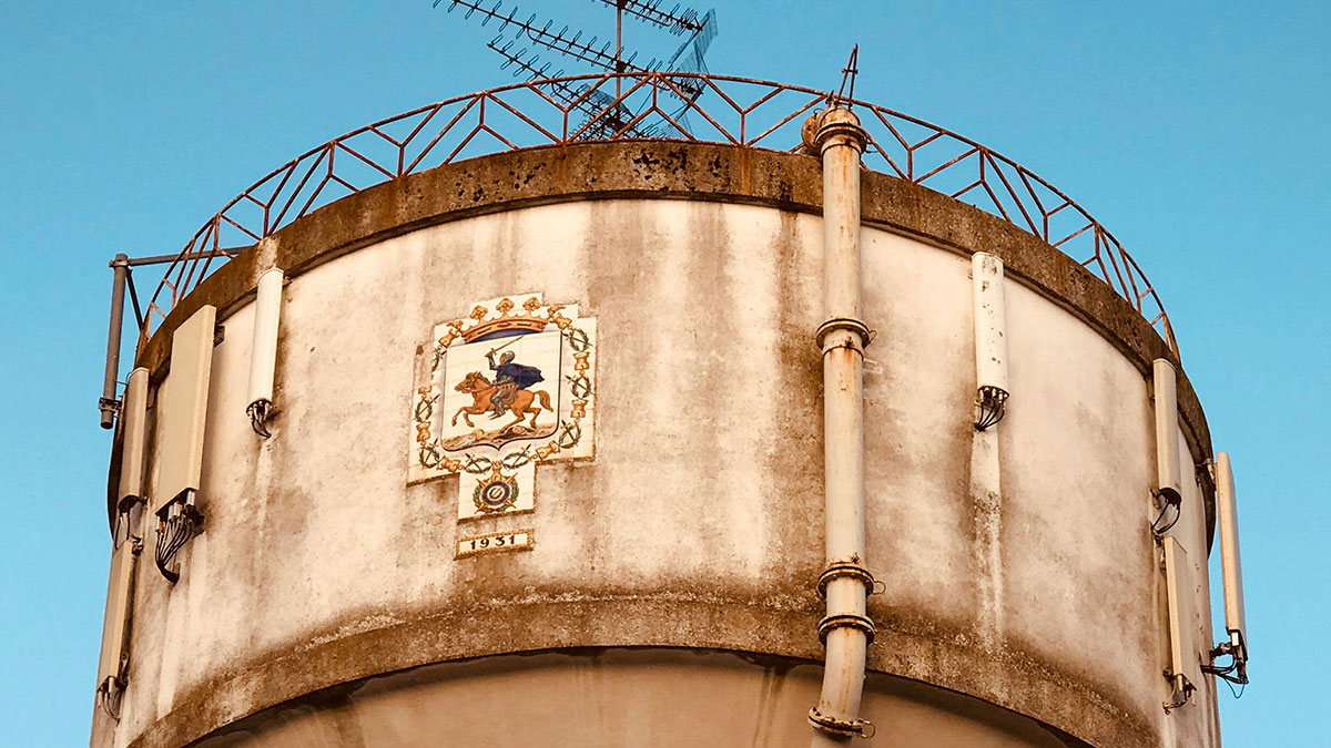 Old concrete water tower with antennas and pipes, illustrating huge risks taken for absolutely no logical reason.