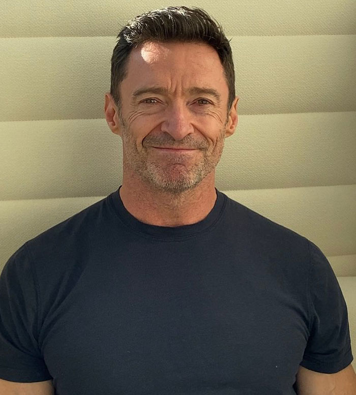 Hugh Jackman smiling in a black t-shirt, highlighting his long history with Sutton Foster amid divorce news. Hugh Jackman smiling in a black t-shirt, highlighting his long history with Sutton Foster amid divorce news.