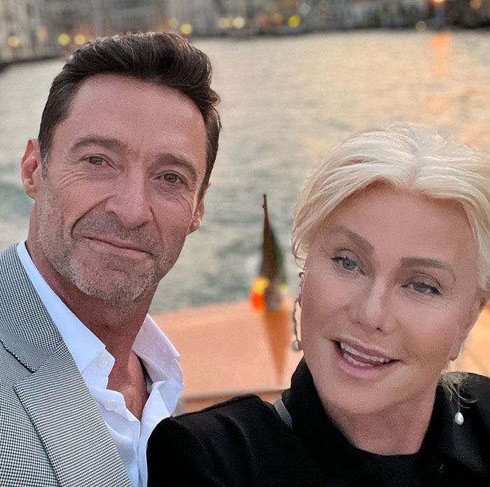Hugh Jackman and Sutton Foster posing outdoors by the water during sunset in a casual selfie. Hugh Jackman and Sutton Foster posing outdoors by the water during sunset in a casual selfie.