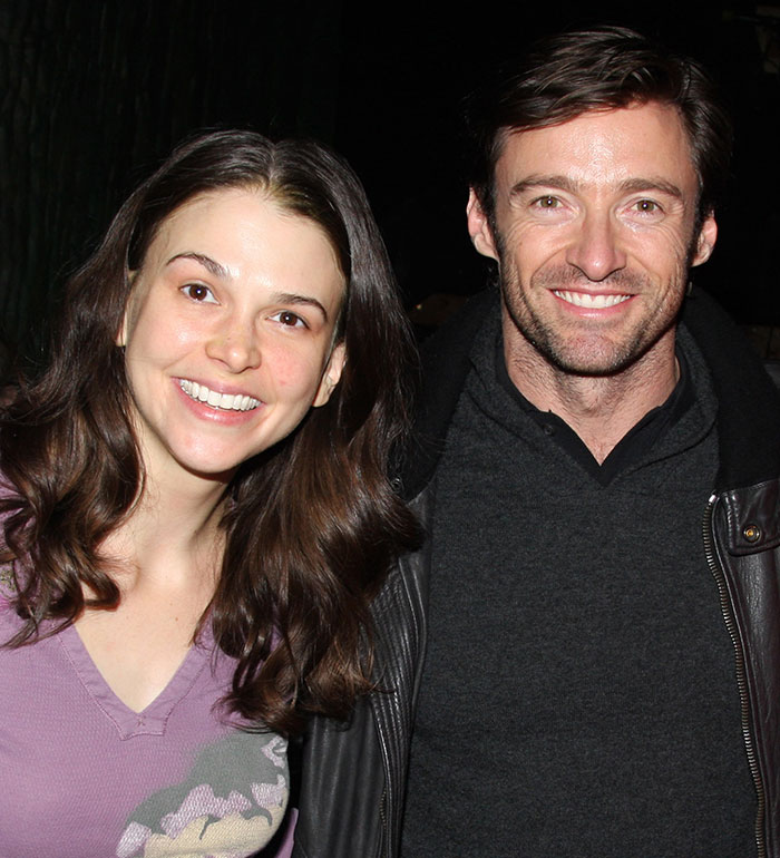Hugh Jackman and Sutton Foster smiling together in a casual setting, highlighting their long history connection. Hugh Jackman and Sutton Foster smiling together in a casual setting, highlighting their long history connection.