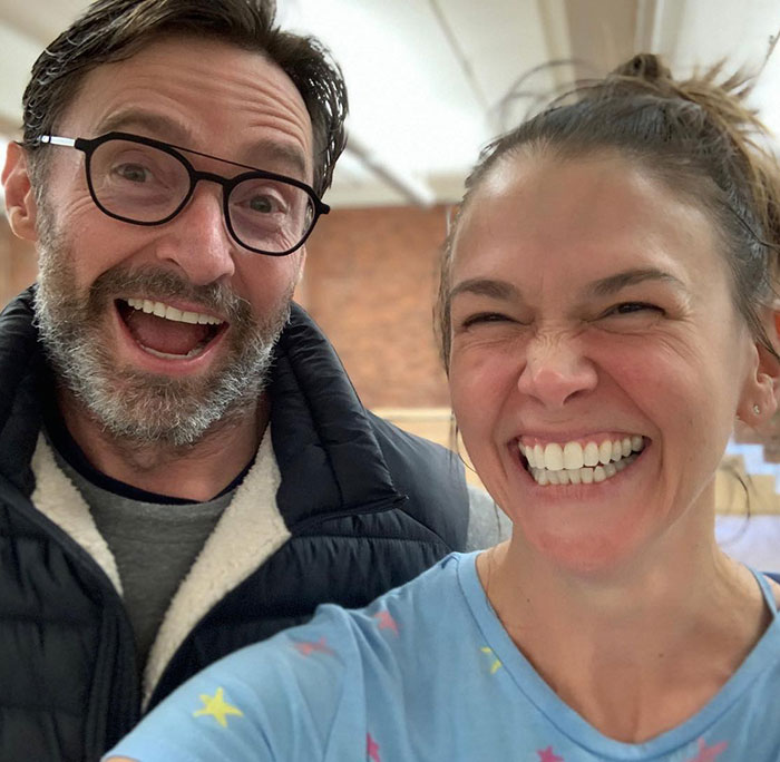 Hugh Jackman and Sutton Foster smiling brightly together in a casual indoor setting, highlighting their history. Hugh Jackman and Sutton Foster smiling brightly together in a casual indoor setting, highlighting their history.