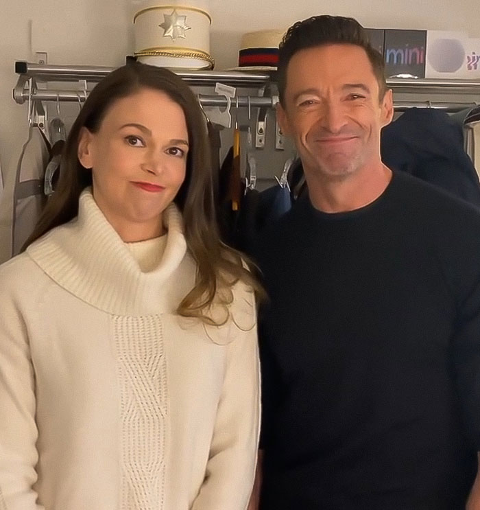 Hugh Jackman and Sutton Foster standing together indoors, smiling, highlighting their long history connection. Hugh Jackman and Sutton Foster standing together indoors, smiling, highlighting their long history connection.
