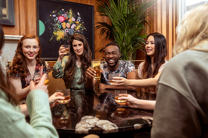 Group of friends raising glasses at a birthday dinner, capturing awkwardness after husband’s tasteless pregnancy stunt on wife Group of friends raising glasses at a birthday dinner, capturing awkwardness after husband’s tasteless pregnancy stunt on wife