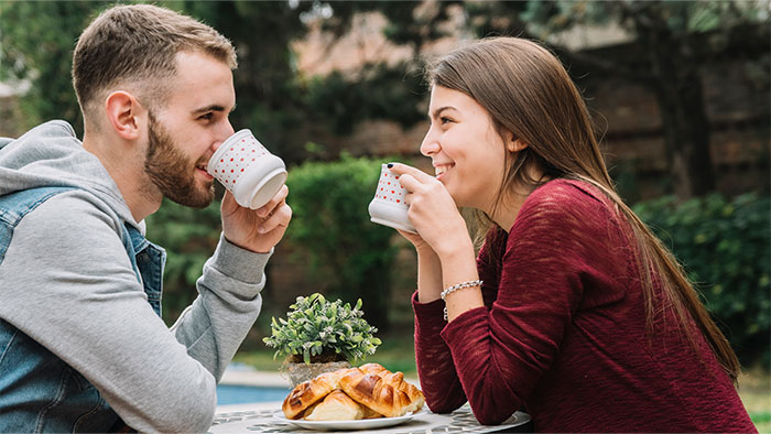 Couple enjoying coffee together outdoors, illustrating a scene of woman's husband being hit on for the first time in life.