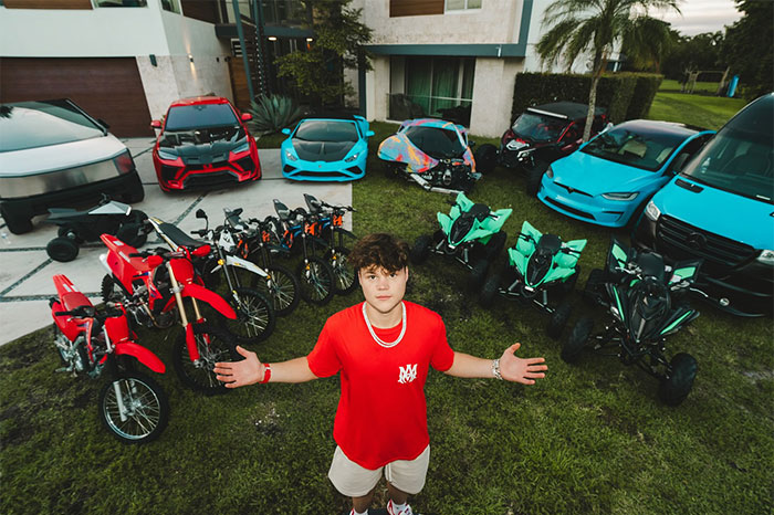 Teenager Jack Doherty posing with luxury vehicles and motorcycles, showcasing his rising net worth and collection.