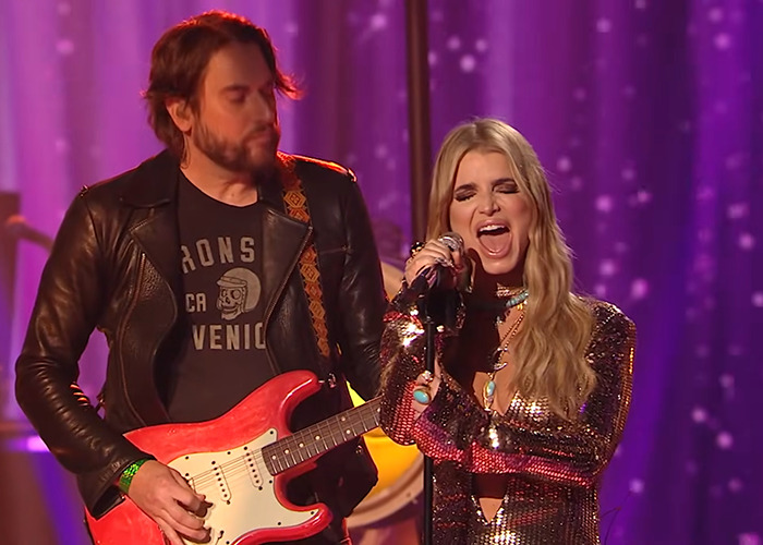 Jessica Simpson performing live on stage with guitarist, facing criticism and described as a train wreck by critics. Jessica Simpson performing live on stage with guitarist, facing criticism and described as a train wreck by critics.