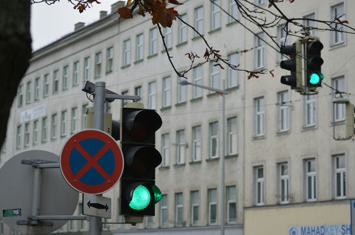 Green traffic lights at an urban intersection representing low-key pleasures and simple moments of happiness.
