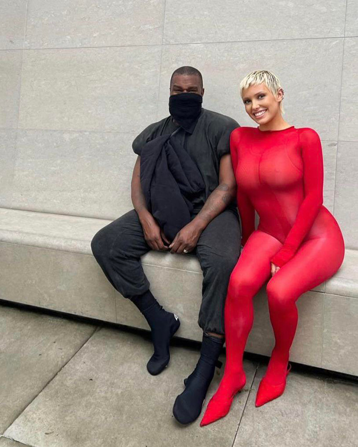 Kanye West sitting next to Bianca Censori in a red outfit, sharing a post about being subservient to her master. Kanye West sitting next to Bianca Censori in a red outfit, sharing a post about being subservient to her master.