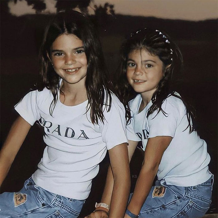 Young Kylie Jenner smiling with a friend outdoors, highlighting Kylie Jenner net worth and early life moments.
