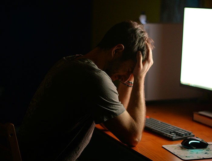Man sitting at a desk with head in hands, appearing stressed over missing iPad and family tension at night. Man sitting at a desk with head in hands, appearing stressed over missing iPad and family tension at night.