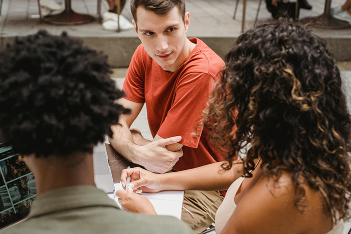 Young employees in a casual meeting, discussing work expectations with a new boss in an outdoor office setting. Young employees in a casual meeting, discussing work expectations with a new boss in an outdoor office setting.