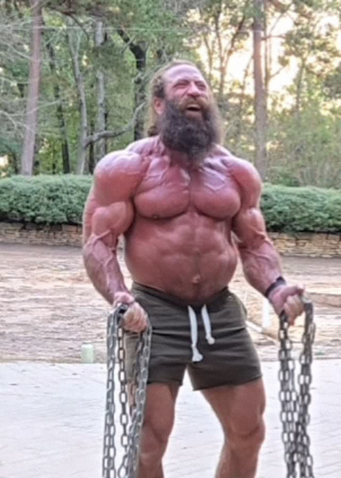 Muscular man outdoors holding heavy chains, embodying the extreme raw animal diet lifestyle of Liver King. Muscular man outdoors holding heavy chains, embodying the extreme raw animal diet lifestyle of Liver King.