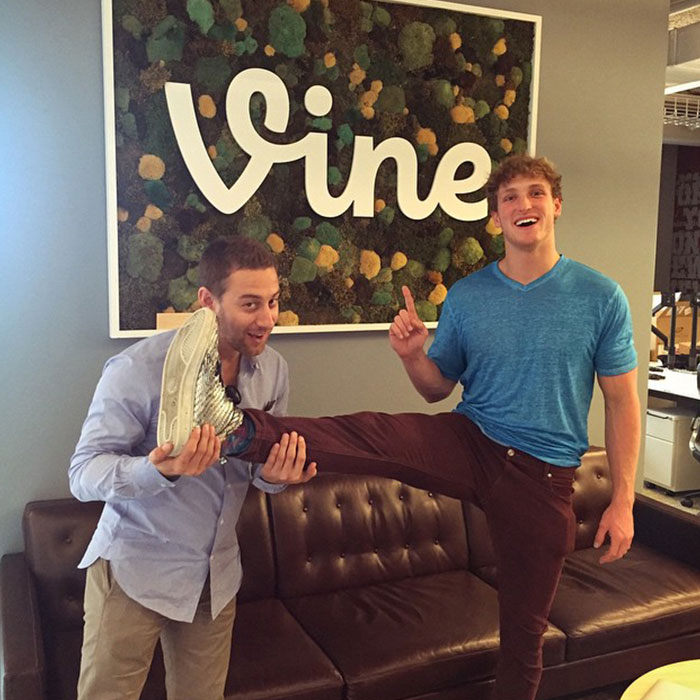 Two men including Logan Paul pose playfully in front of a Vine sign, illustrating moments from Logan Paul net worth after prime discussions.